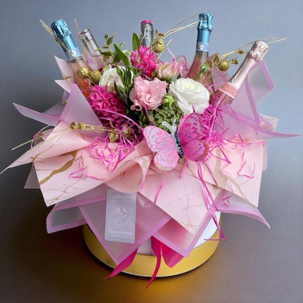 Pink and white flower bouquet with champagne bottles and a butterfly decoration
