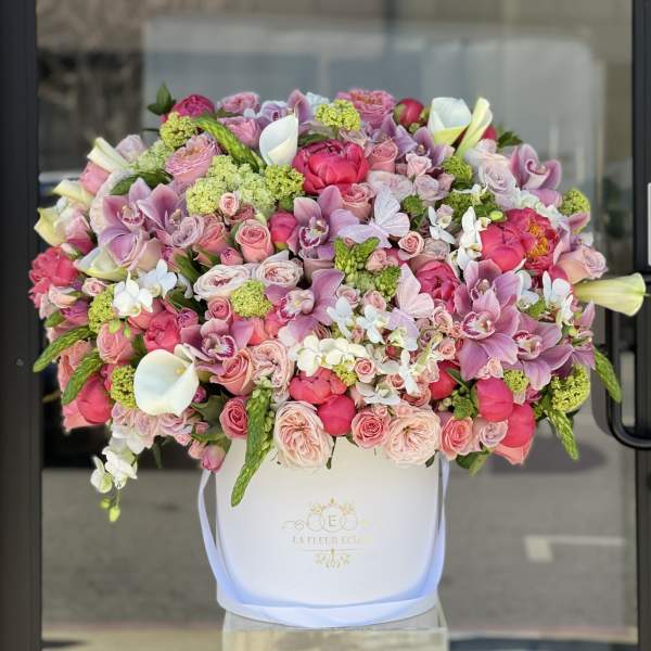 Large pink and white mixed flower arrangement in a white hat box