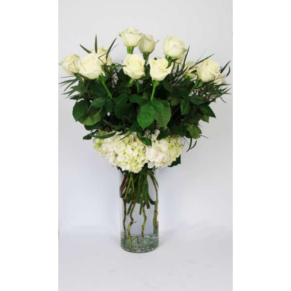 White roses and hydrangeas in a clear glass vase