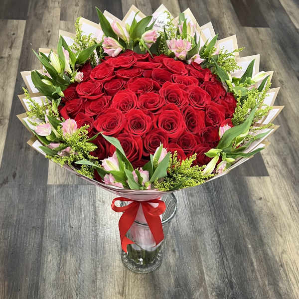 Bouquet of red roses with pink lilies in a glass vase