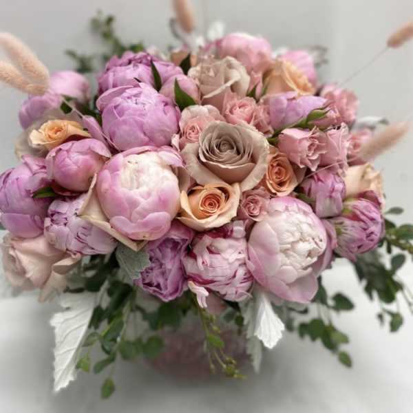 Pink and peach bouquet of peonies and roses in a vase