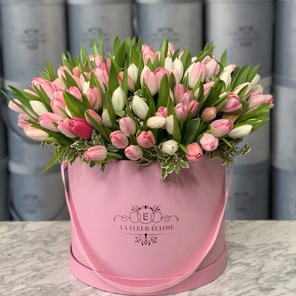 Pink and white tulips arranged in a pink hatbox