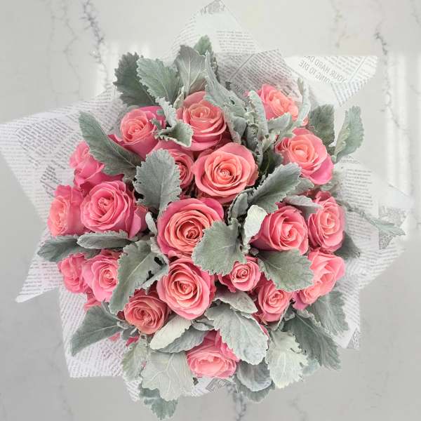 Bouquet of pink roses wrapped in newspaper-style paper