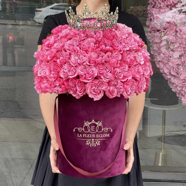 Large pink rose arrangement in a velvet hatbox with a jeweled crown