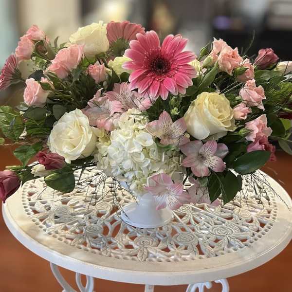 Pink and white mixed flower arrangement in a white vase