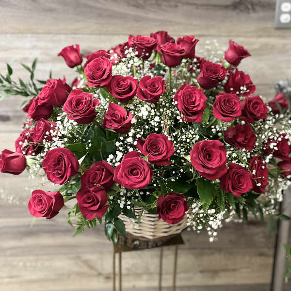 Basket arrangement of red roses with baby's breath