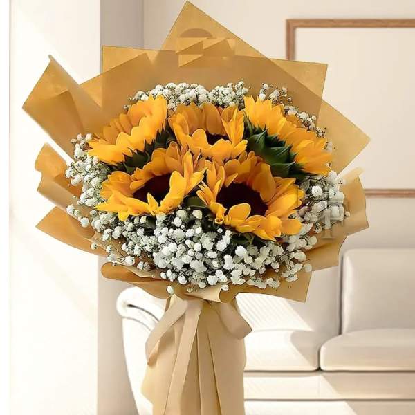 Bouquet of sunflowers wrapped in tan paper with white filler flowers