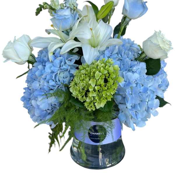 Blue hydrangeas and white lilies with roses in a glass vase