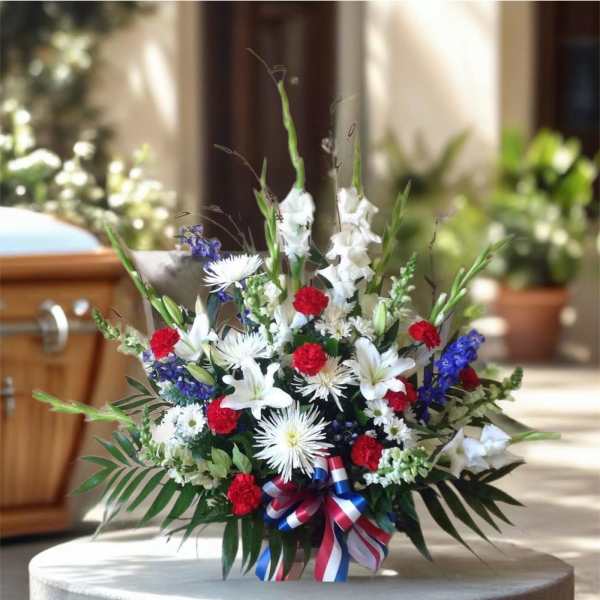Red, white, and blue floral arrangement with a ribbon bow