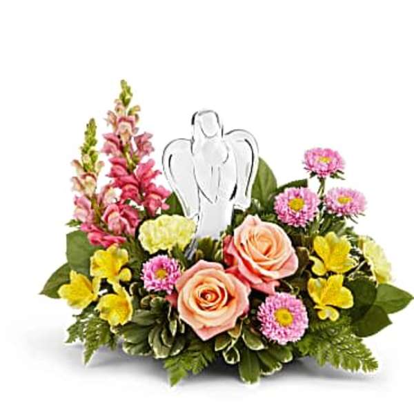 Pink and yellow floral arrangement with a white angel pick