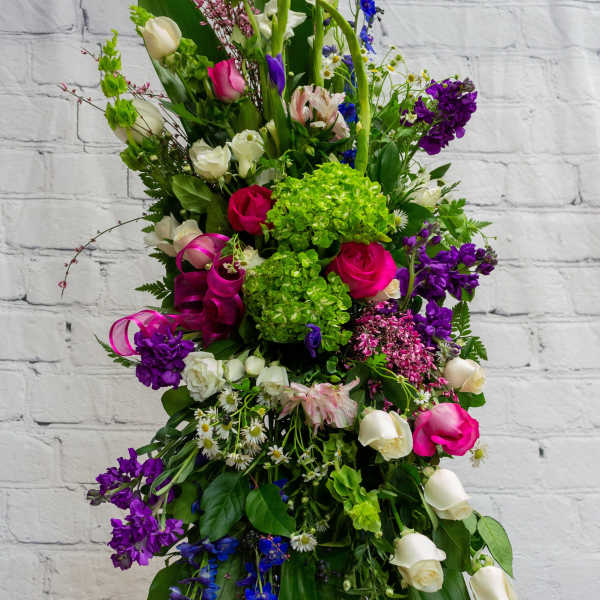 Tall mixed floral arrangement with pink, white, purple, and blue blooms