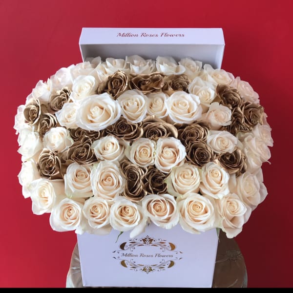 Boxed arrangement of cream and brown roses against a red background