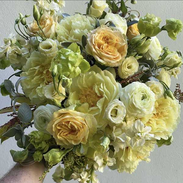 Bouquet of pale yellow and white flowers with green accents