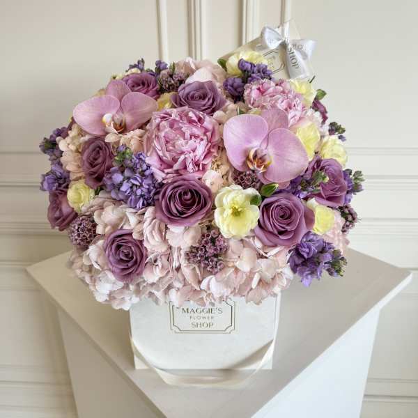 Bouquet of pink and purple flowers in a white box