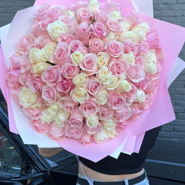 Large bouquet of pink and cream roses wrapped in pink paper