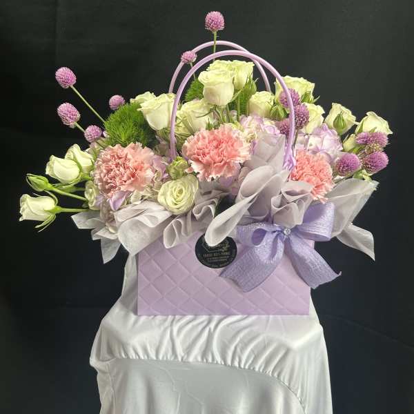 Lavender gift box with pastel roses, carnations, and purple accents