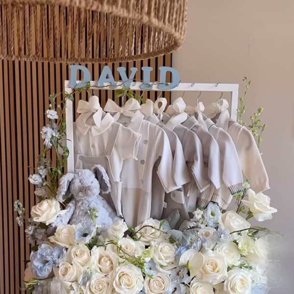 White floral gift box with baby clothes, a plush bunny, and the name David