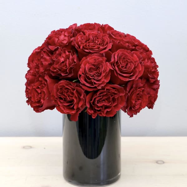 Red roses arranged in a black vase