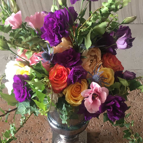 Colorful bouquet of roses and lisianthus in a silver vase