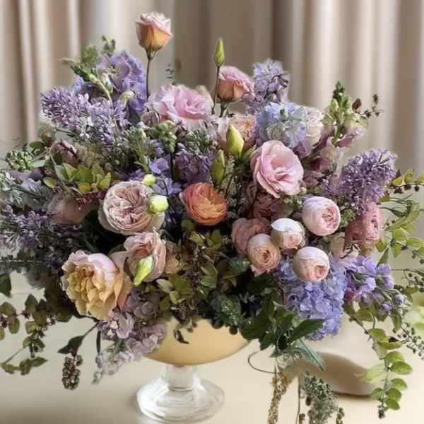 Pastel bouquet of roses and hydrangeas in a pedestal vase