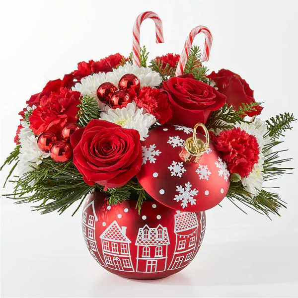Christmas bouquet with red roses, white daisies, and candy cane picks in a red ornament vase