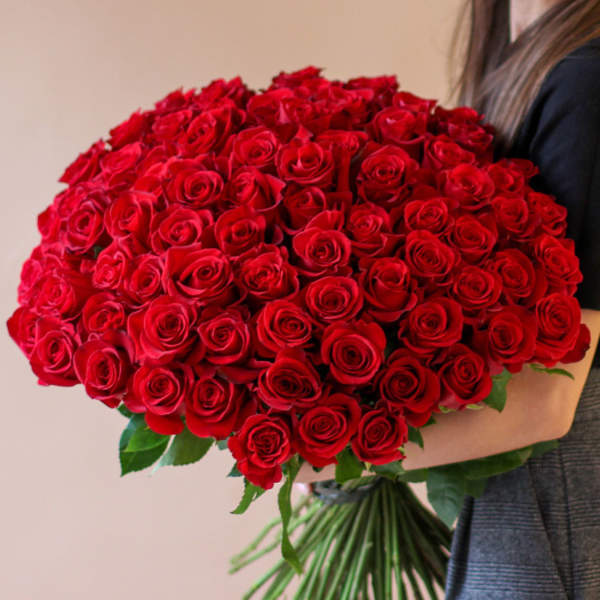 Large bouquet of red roses held in someone's arms