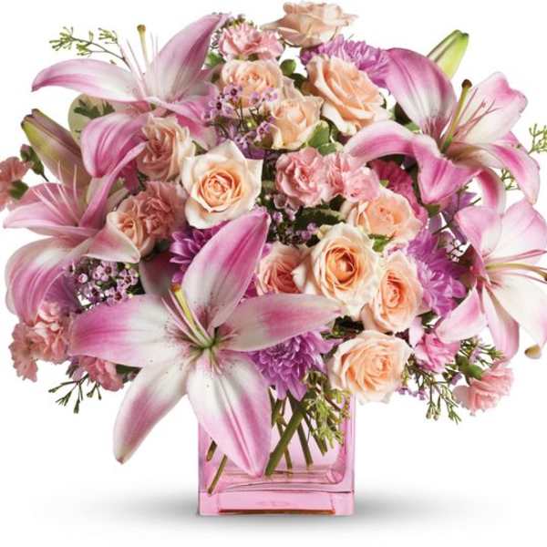 Pink lilies and peach roses in a pink glass vase