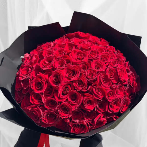 Large bouquet of red roses wrapped in black paper