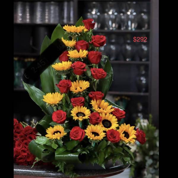 Tiered arrangement of red roses and yellow sunflowers