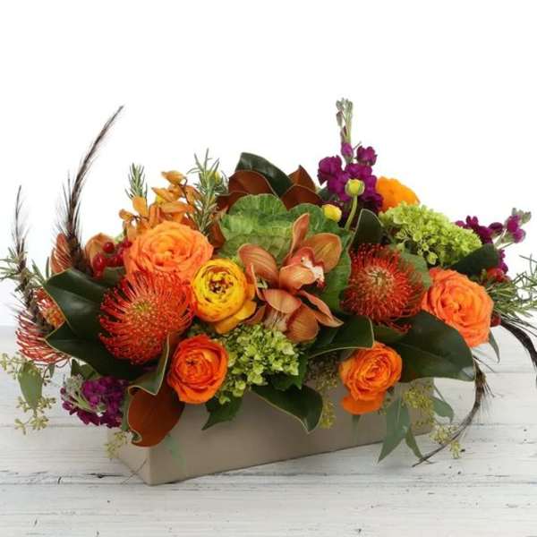 Orange and purple floral arrangement in a rectangular box