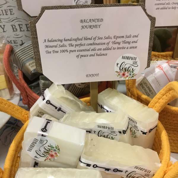 Basket of wrapped bath salt bars with a sign reading Balanced Journey