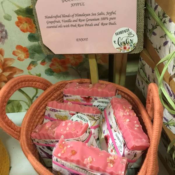 Basket of pink handmade soaps with floral packaging