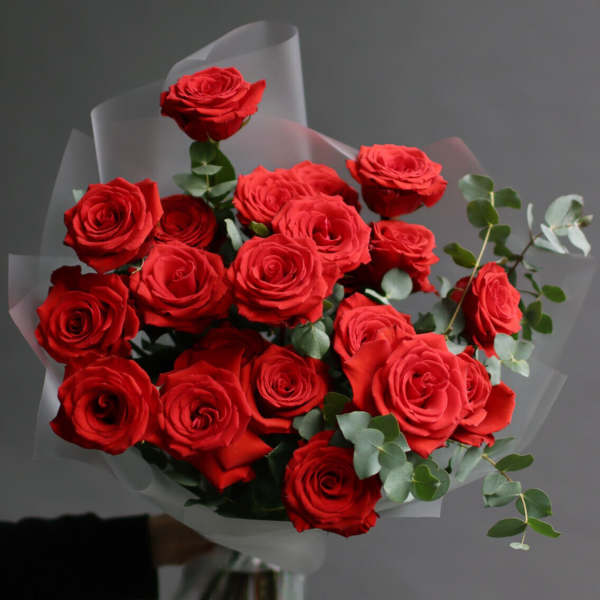 Bouquet of red roses wrapped in translucent paper
