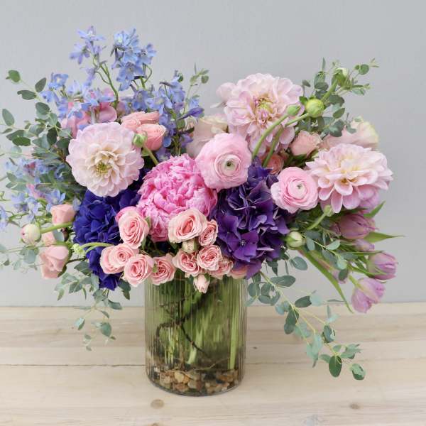 Pink and purple mixed flower arrangement in a glass vase