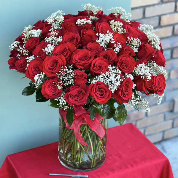 Bouquet of red roses and white baby's breath in a glass vase