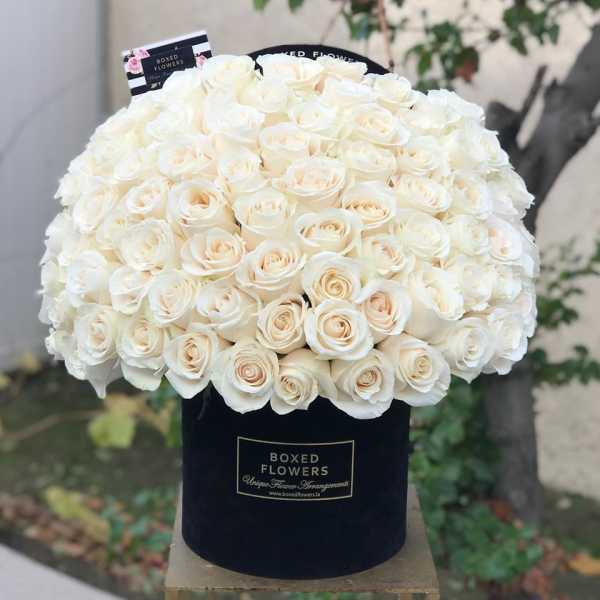 Large bouquet of white roses in a black hat box