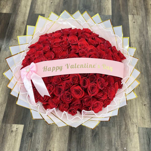 Large bouquet of red roses with a pink Valentine’s Day ribbon