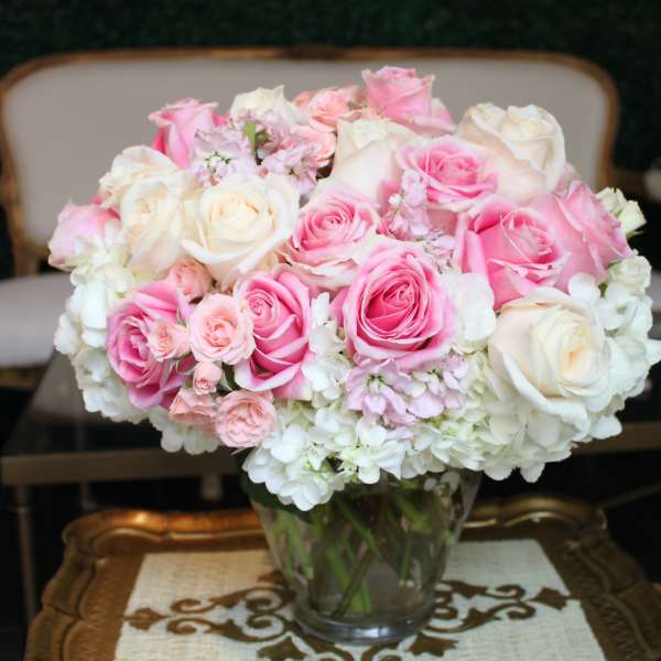 Pink and white roses arranged in a clear glass vase