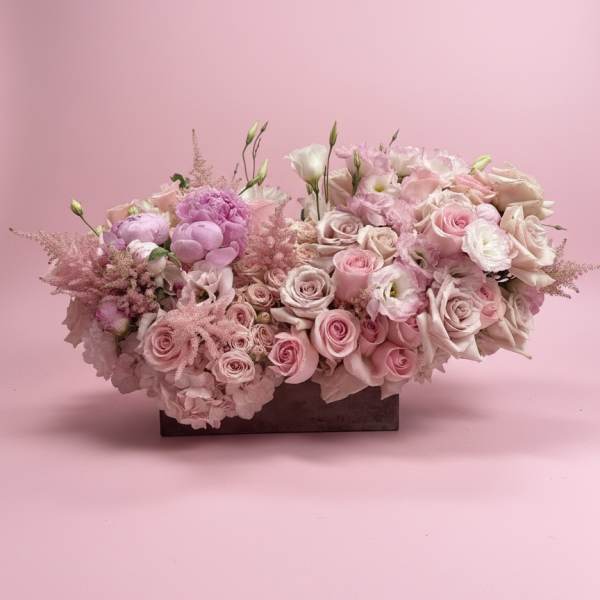Pink and white rose arrangement in a low rectangular container