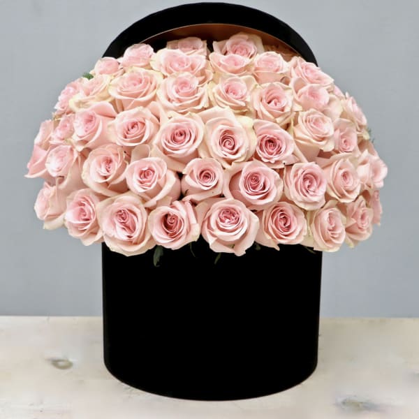 Round box filled with pale pink roses