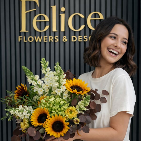 Woman holding a bouquet of sunflowers and white flowers