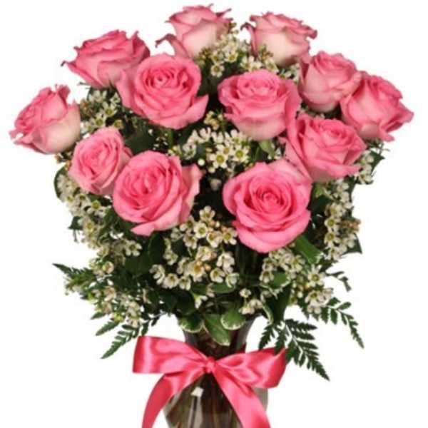 Pink roses in a glass vase with a pink ribbon