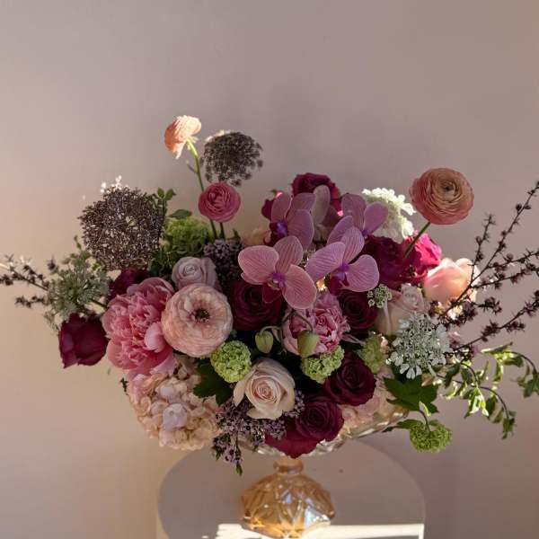 Mixed pink and burgundy bouquet in a decorative glass vase