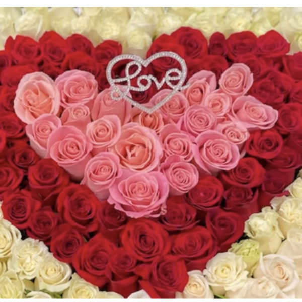 Heart-shaped rose arrangement with a Love topper