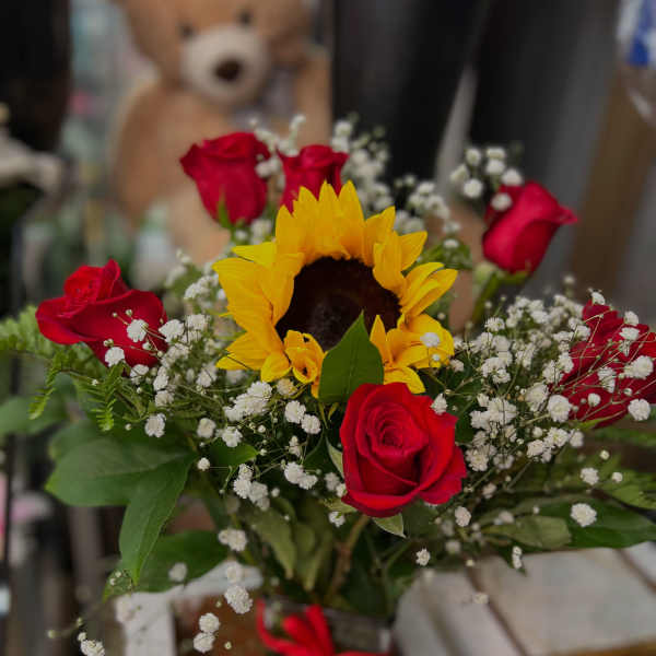 Bouquet of red roses and a sunflower with baby's breath