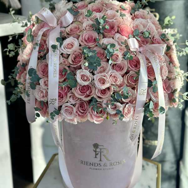 Pink rose arrangement in a pale pink hat box with ribbon accents