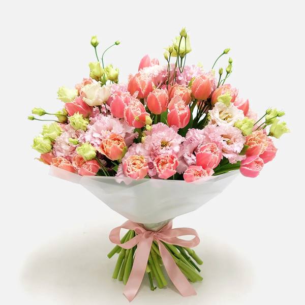 Bouquet of pink and peach tulips with pale pink blooms wrapped in white paper