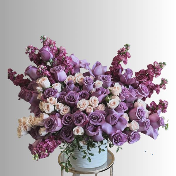 Lavender and blush roses arranged in a white vase