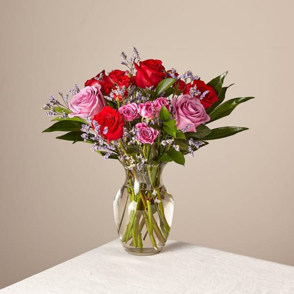 Bouquet of red and pink roses in a clear glass vase