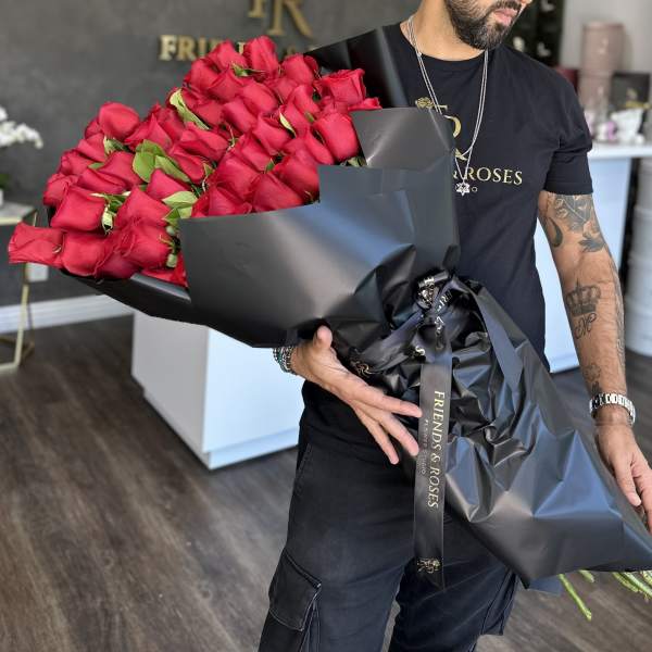 Large bouquet of red roses wrapped in black paper